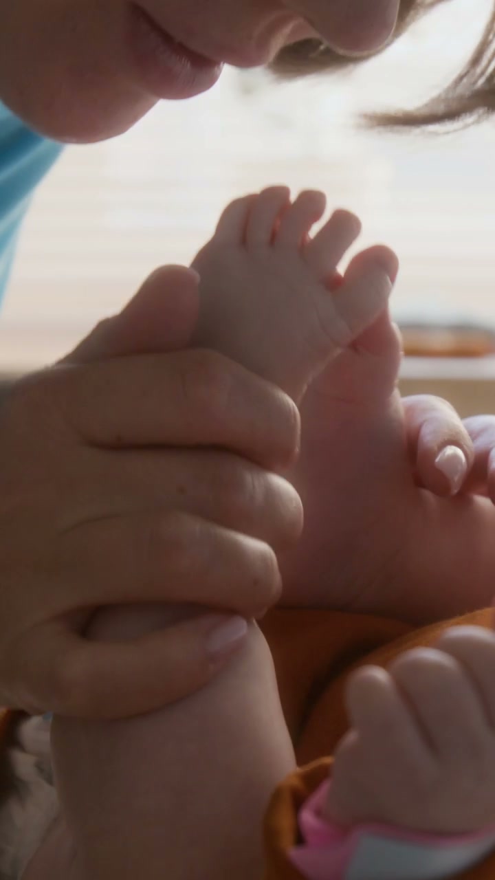 Mother Kisses Newborn Baby's Feet