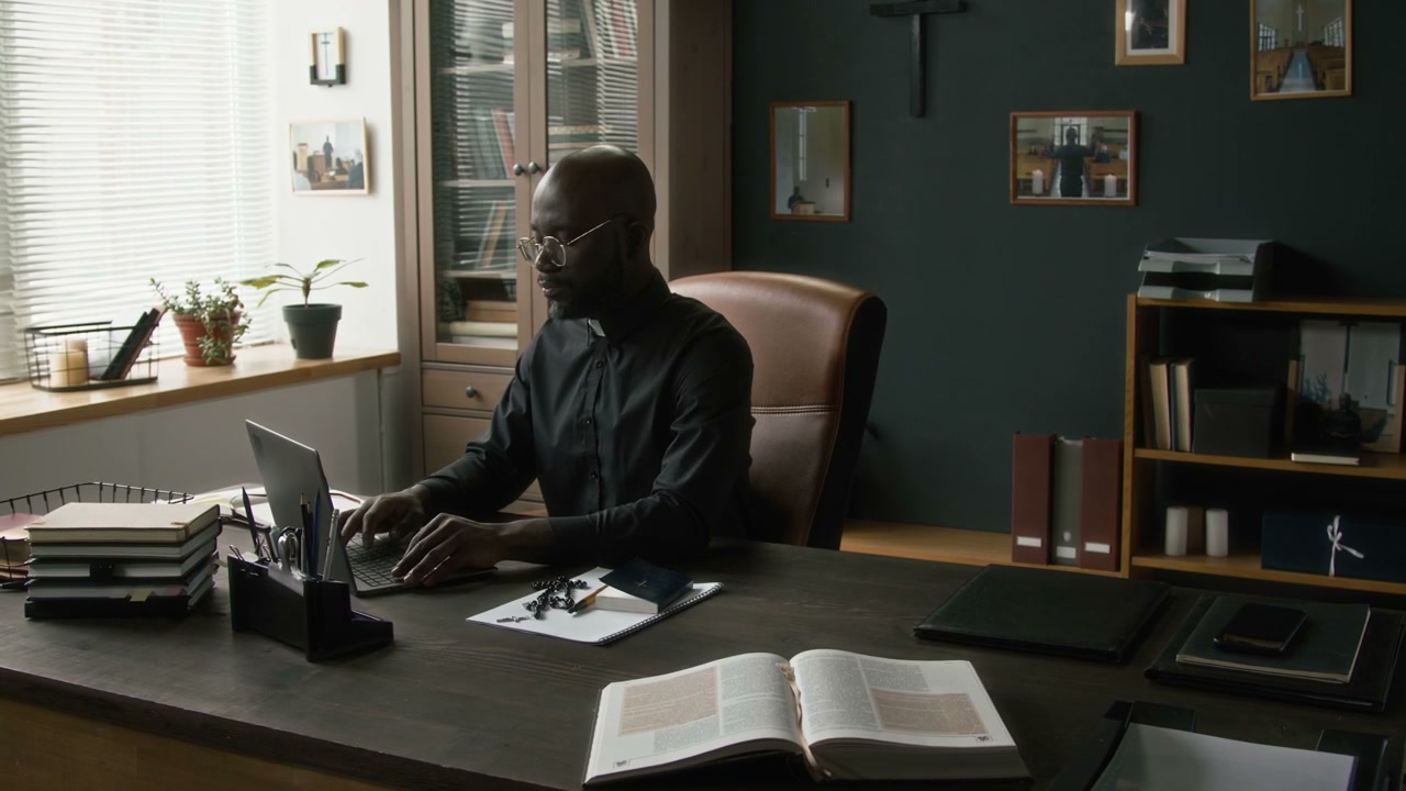 Pastor Working on Laptop in Office