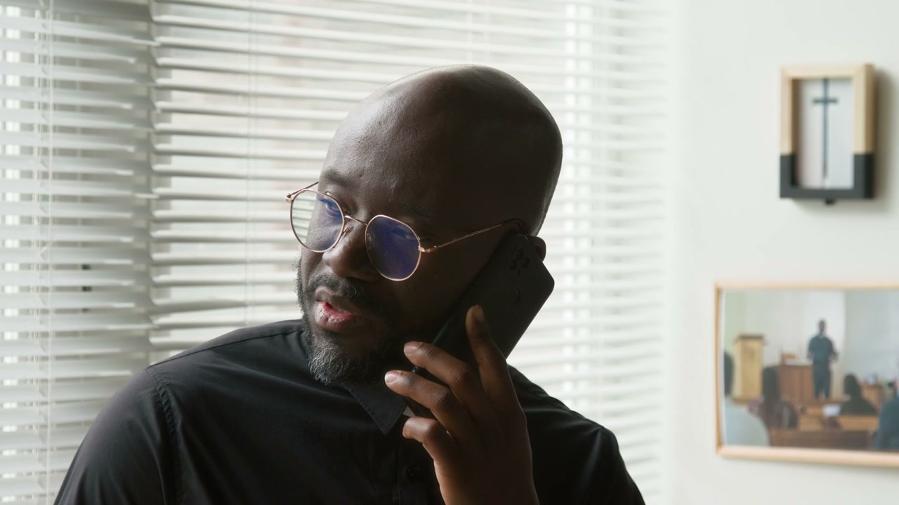 Black Priest Talking on Smartphone Call