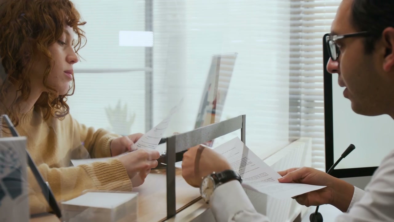 Bank Employee Discusses Documents with Customer