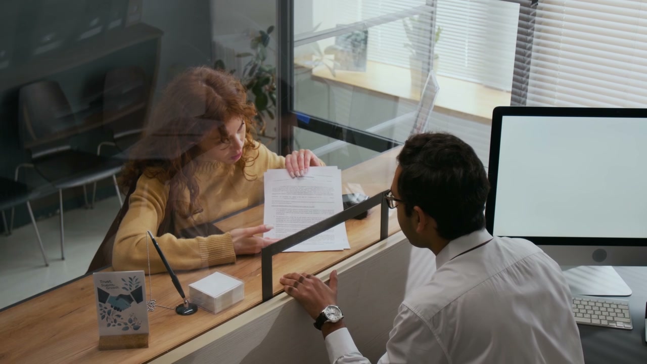 Woman Discussing Documents with Bank Teller