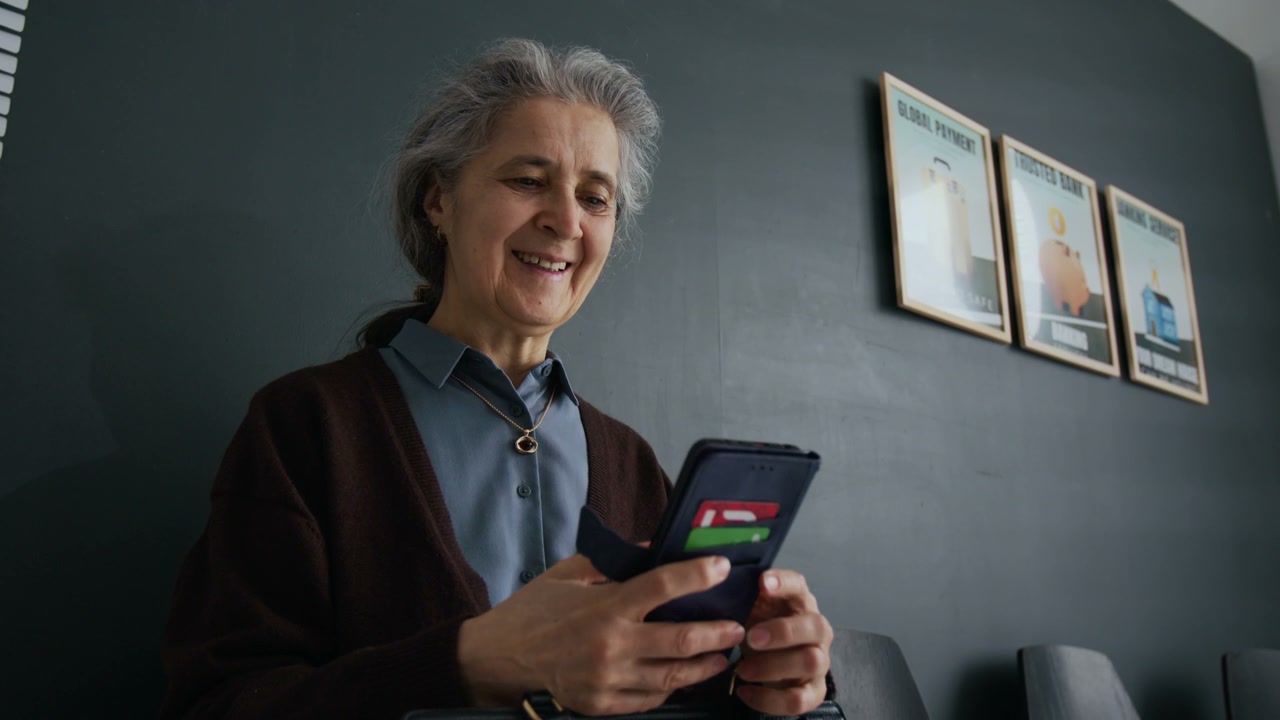 Senior Woman Using Phone in Bank Lobby