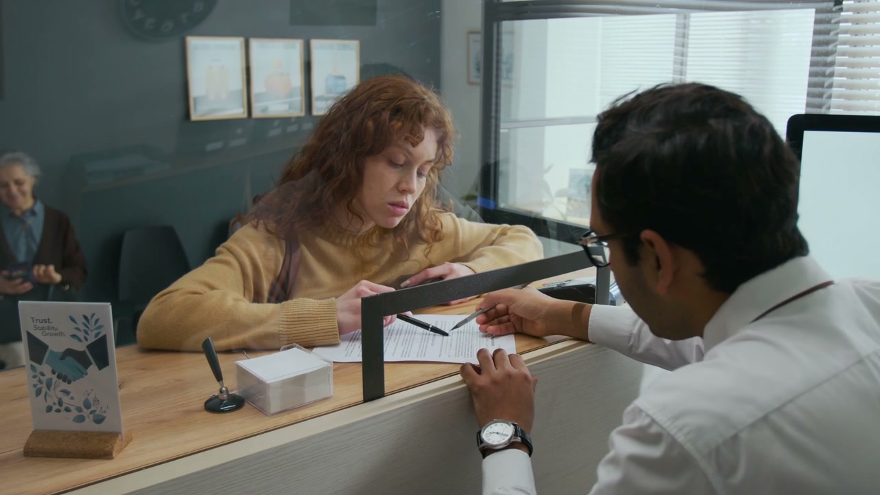Customer Signs Bank Document with Teller