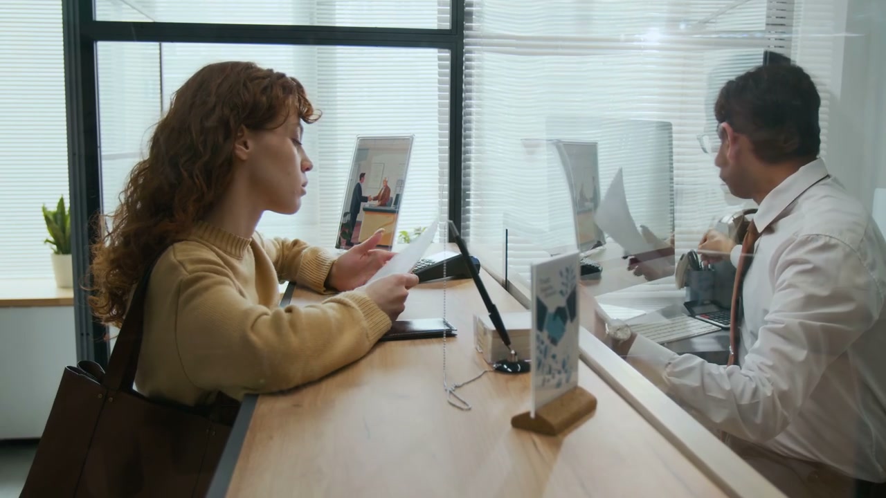 Woman Signing Document with Bank Employee