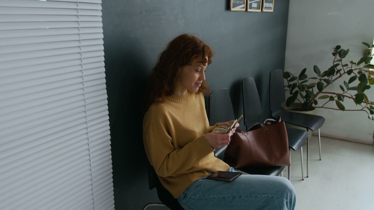 Woman Counting Dollar Bills in Office