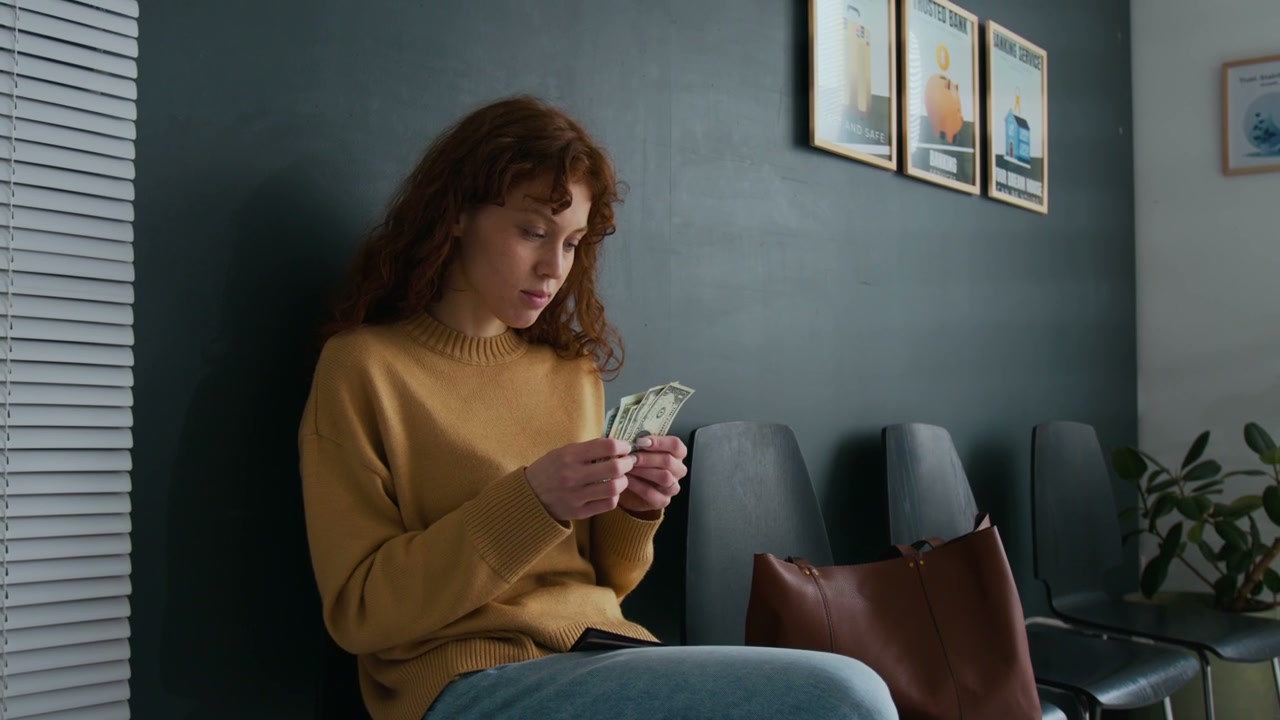 Woman Counting Cash in Waiting Room