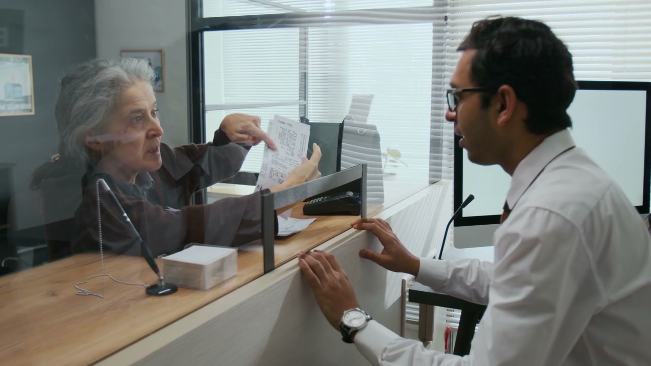 Senior Woman Discusses Documents with Bank Employee