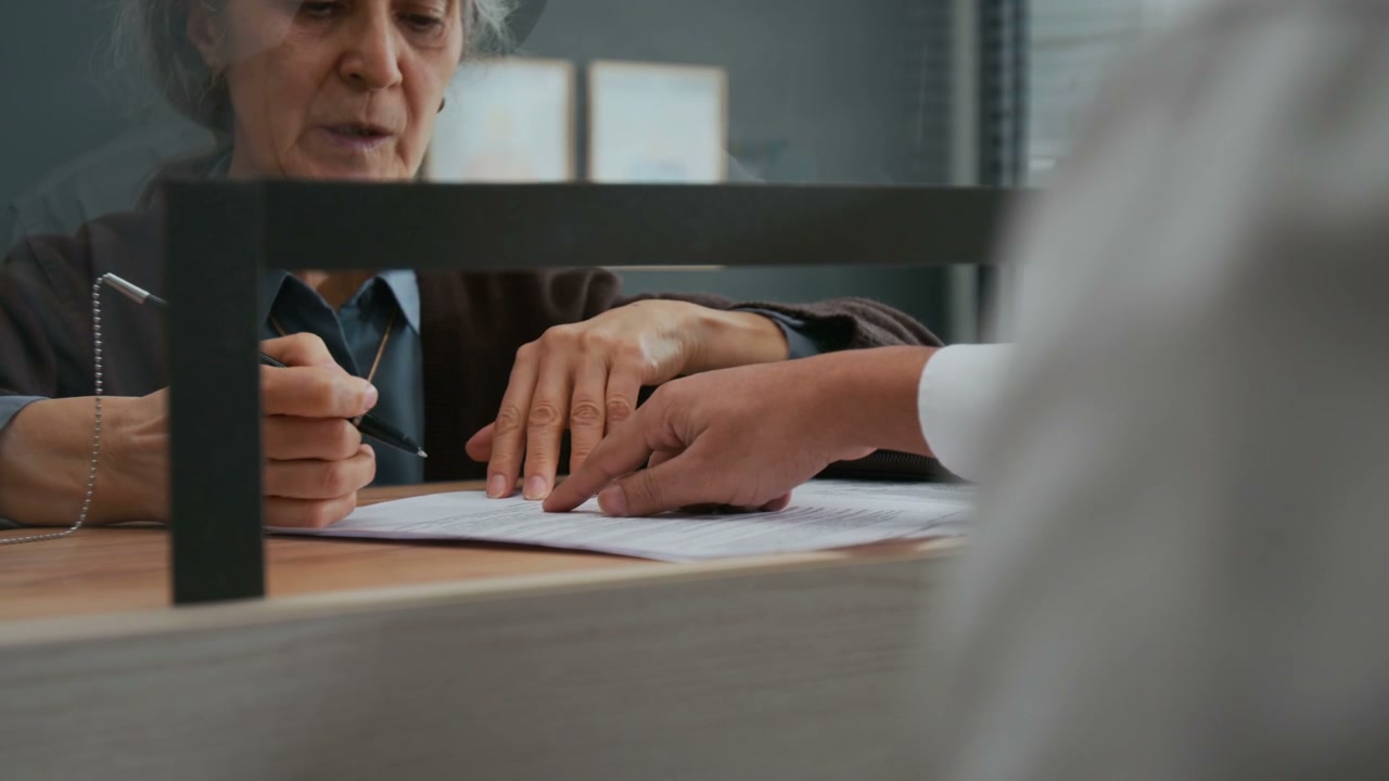 Elderly Woman Signing Bank Documents