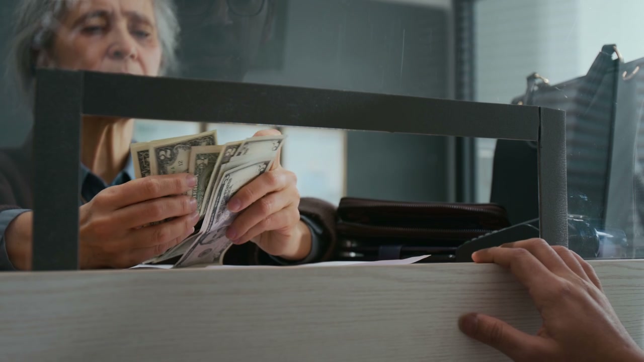 Unrecognizable Bank Worker Counting Dollar Bills