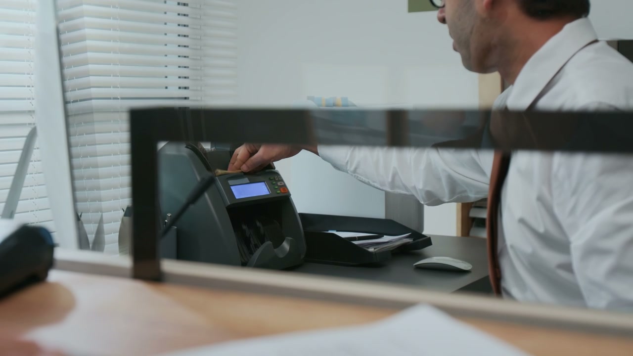 Bank Teller Counting Cash with Money Machine