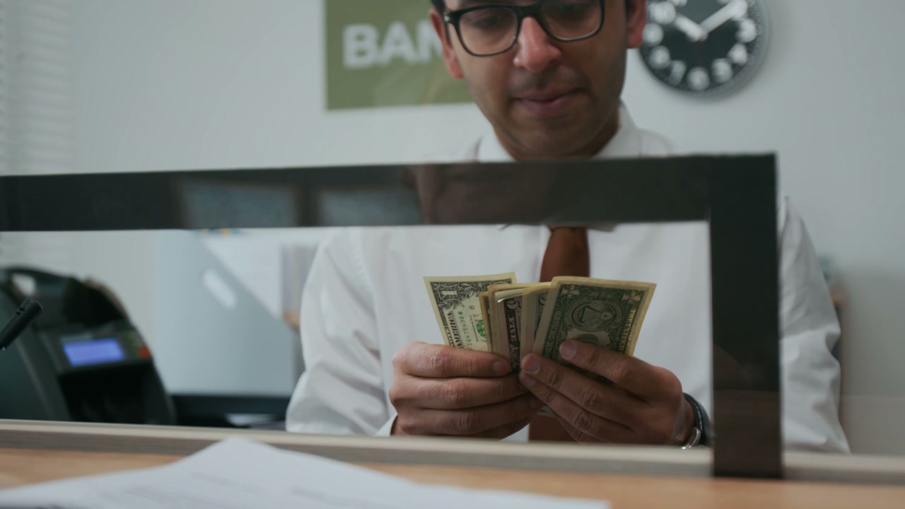 Close-up of Employee Counting Stacks of American Dollar Bills in Bank Office