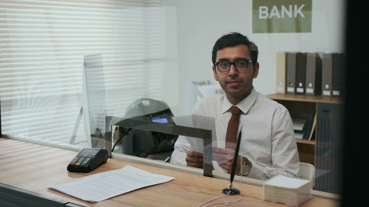 Bank Employee Looking at Camera in Office