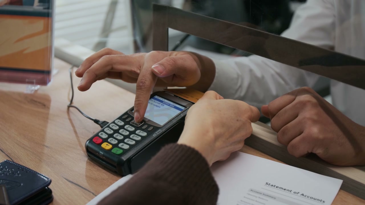 Customer Paying with Credit Card at Bank Counter