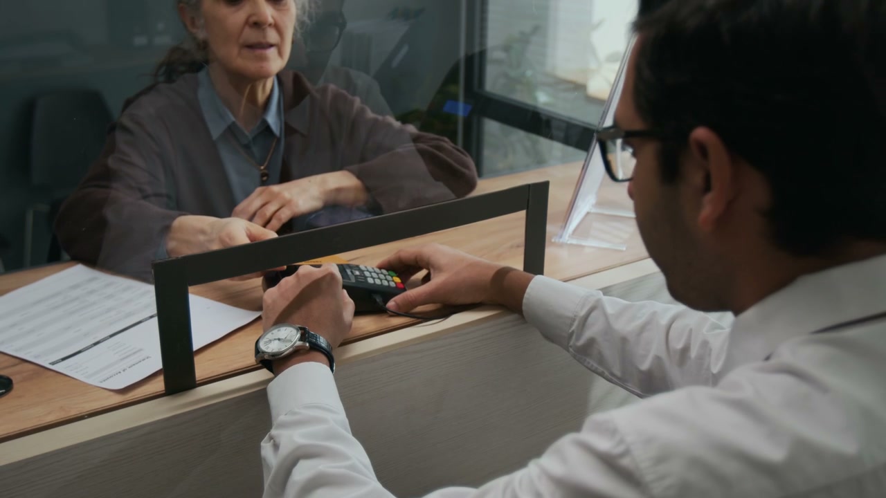 Customer Using Payment Terminal at Bank Counter