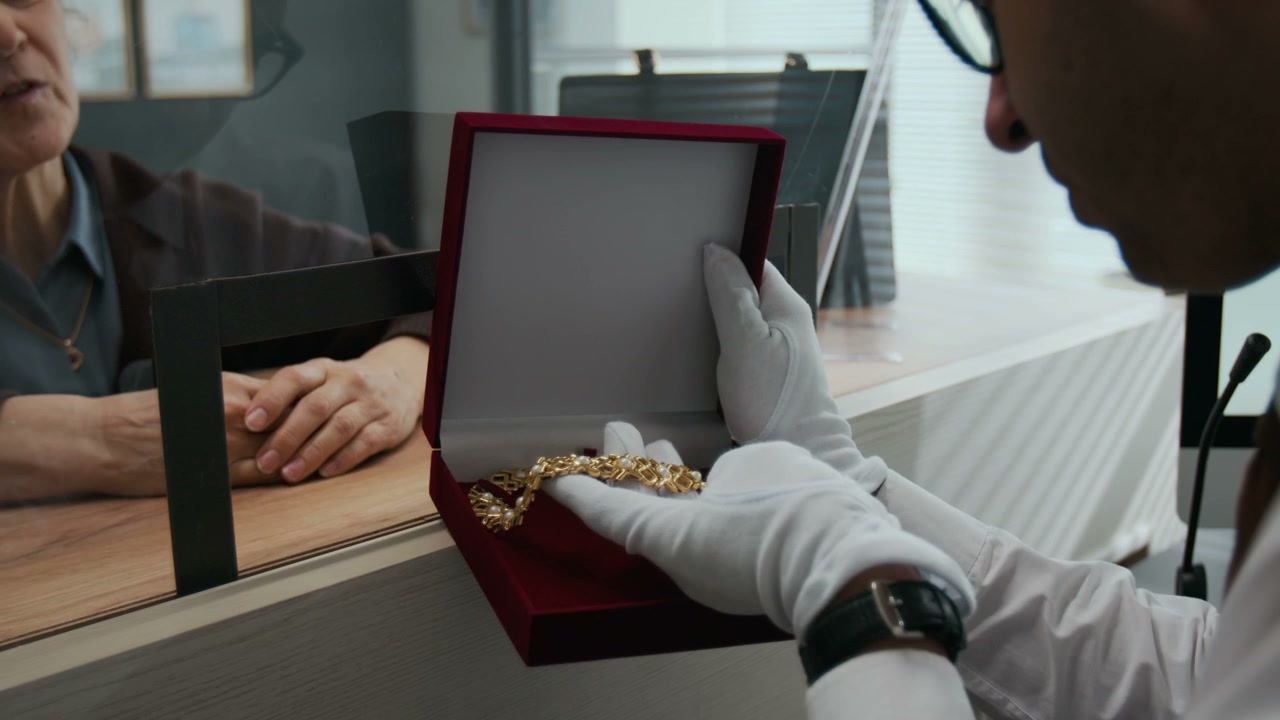 Jeweler Shows Gold Necklace To Customer