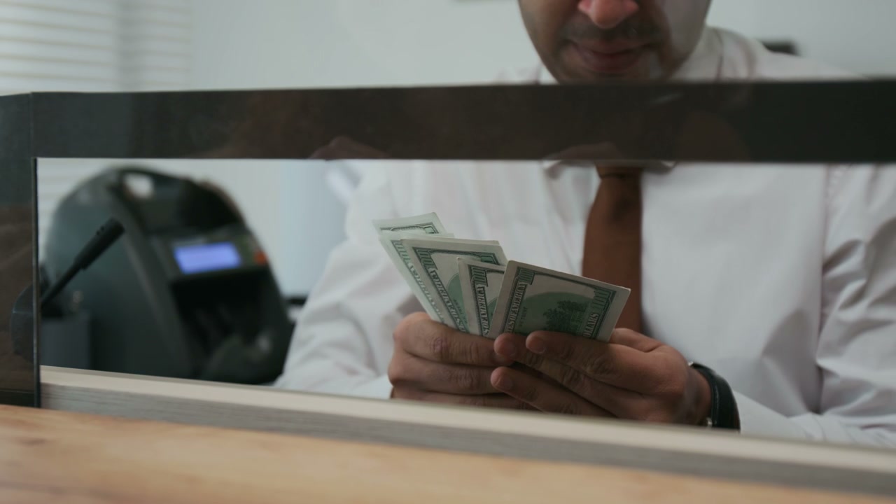 Bank Teller Counting US Dollar Bills