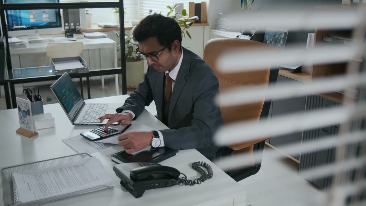 Man Calculating Finances in Modern Office