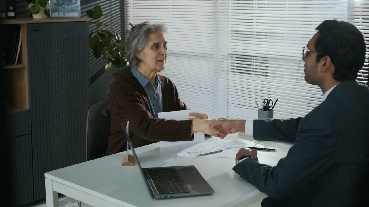 Elderly Woman Receiving her Credit Card in Bank Office
