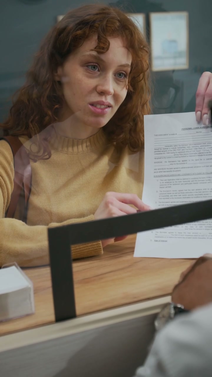 Woman Discussing Document at Bank Counter