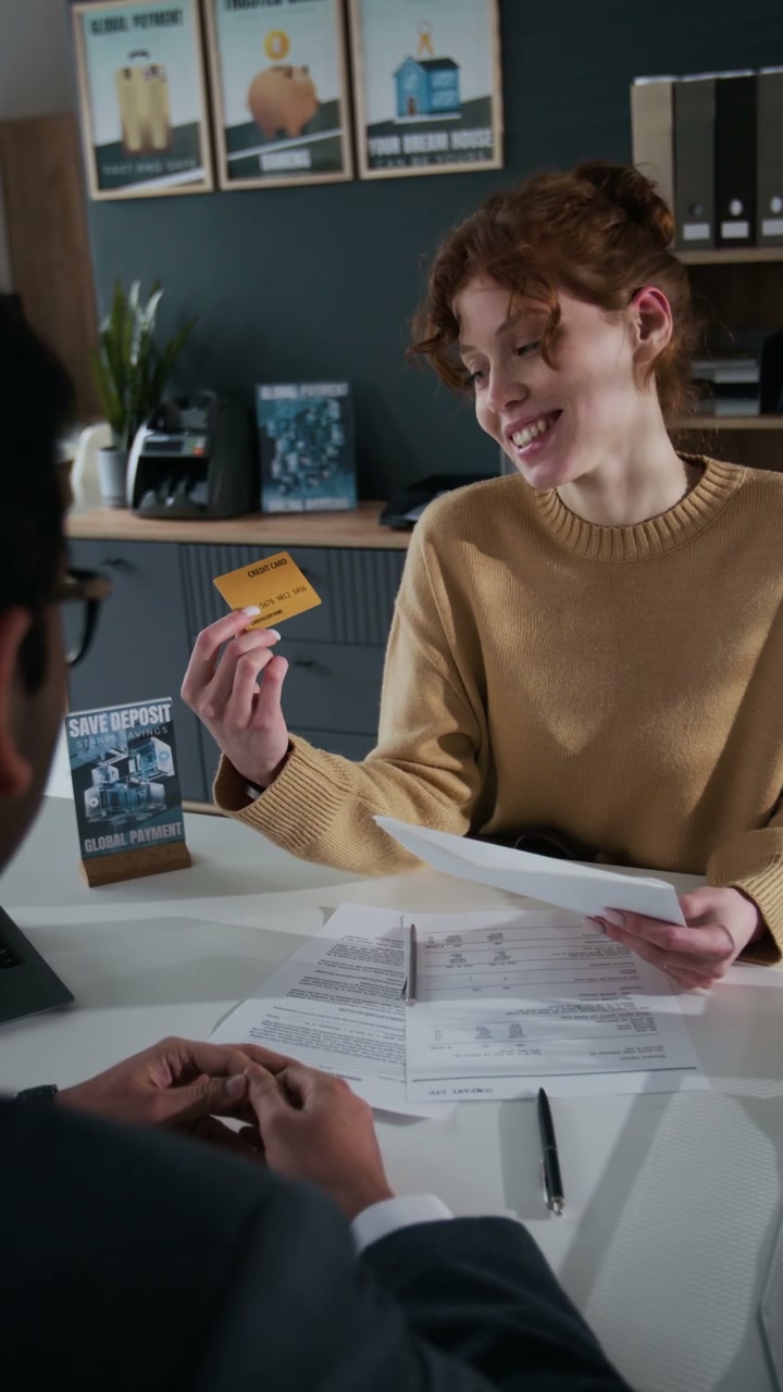 Happy Woman Holding Credit Card in Bank
