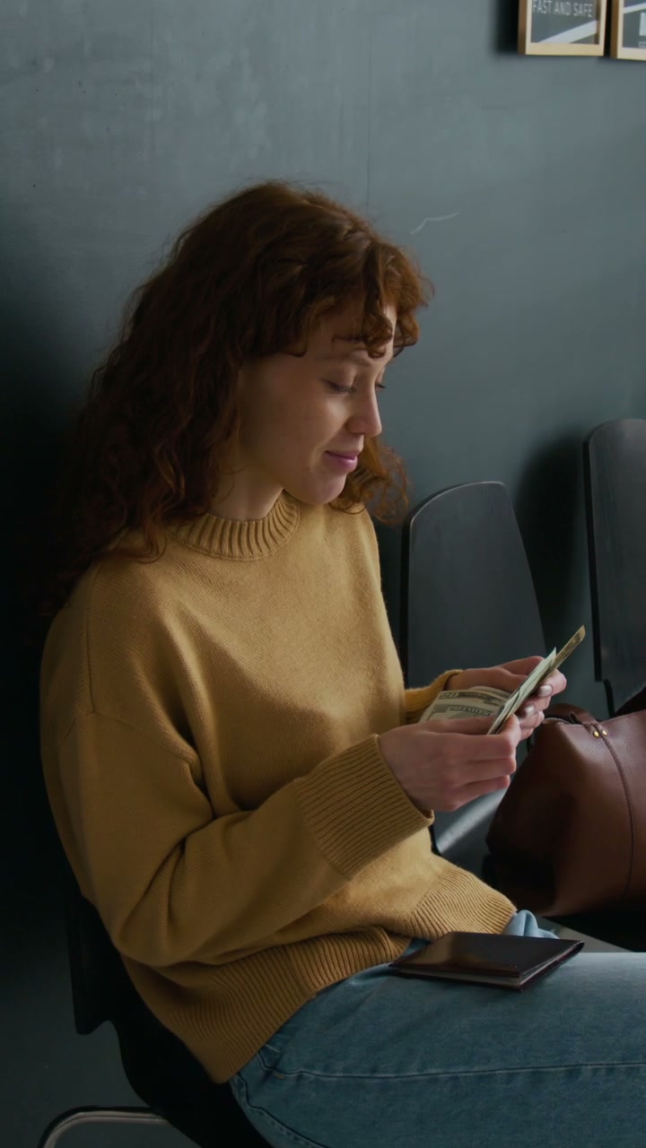 Woman Counting Dollar Bills in Bank