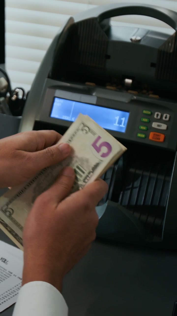 Person Counting Money with Machine