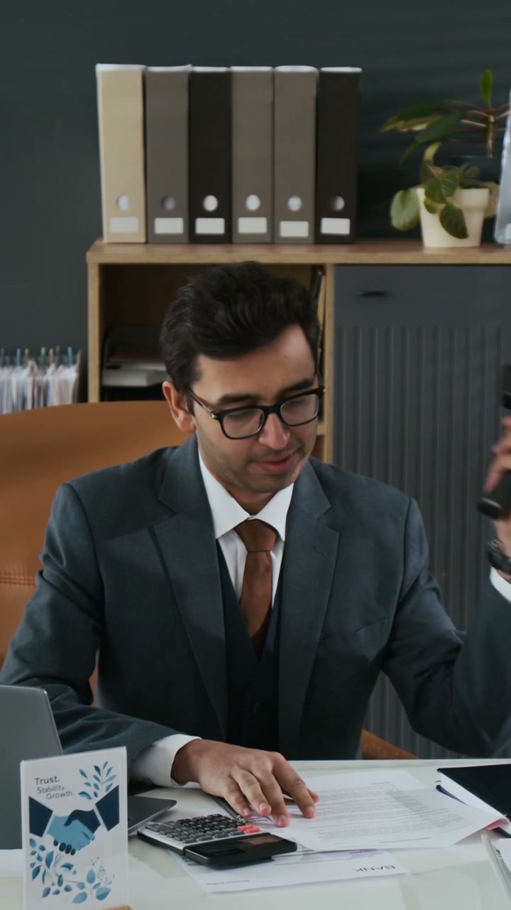 Businessman Talking on Phone and Reviewing Documents