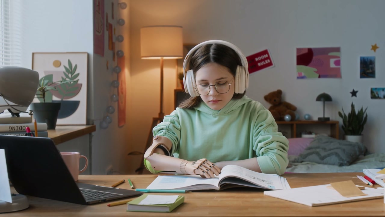 Young Student with Prosthetic Arm Studies at Desk