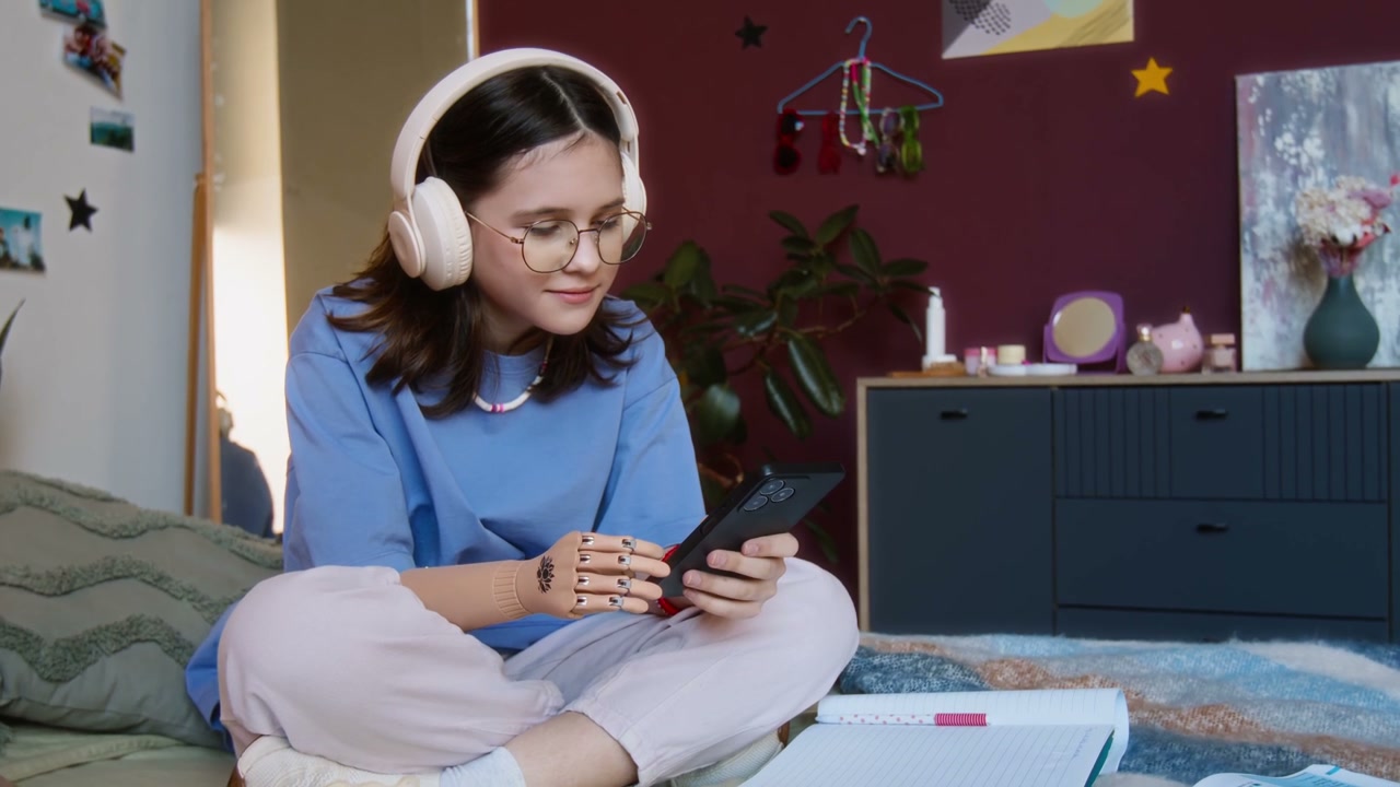 Teenage Girl With Prosthetic Arm Using Smartphone