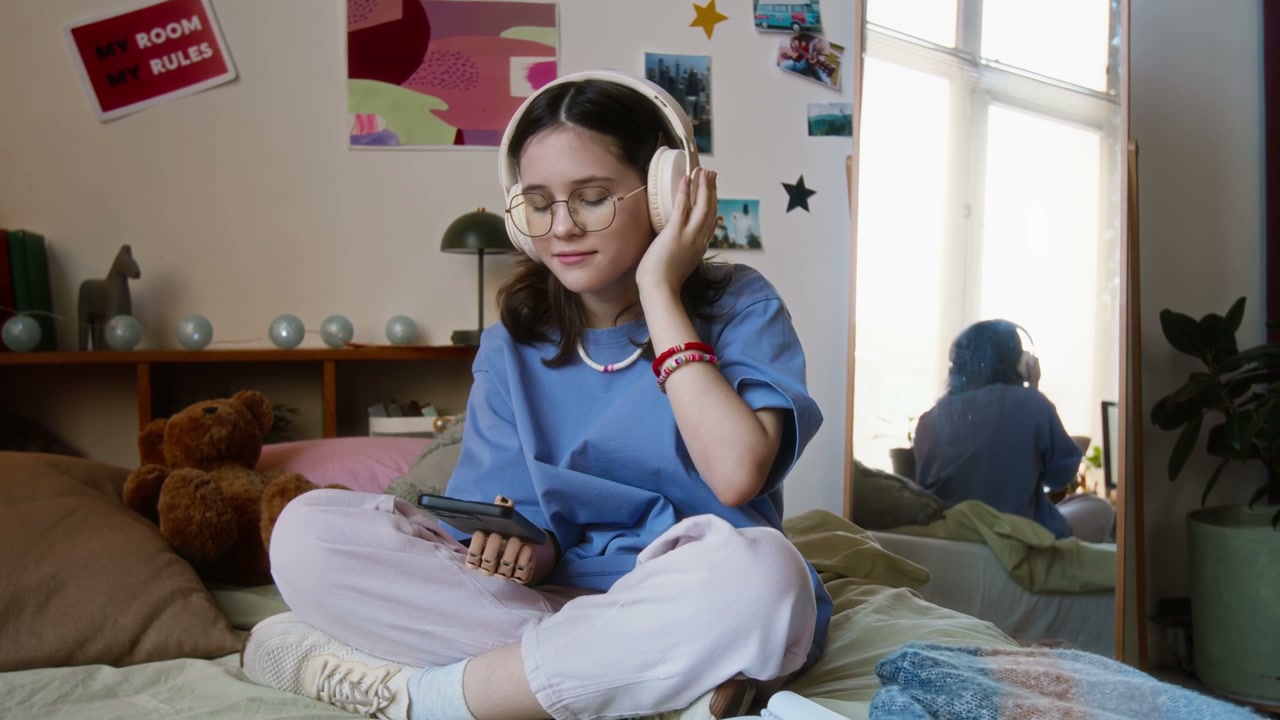 Teenage Girl With Prosthetic Arm Listening to Music in Bedroom