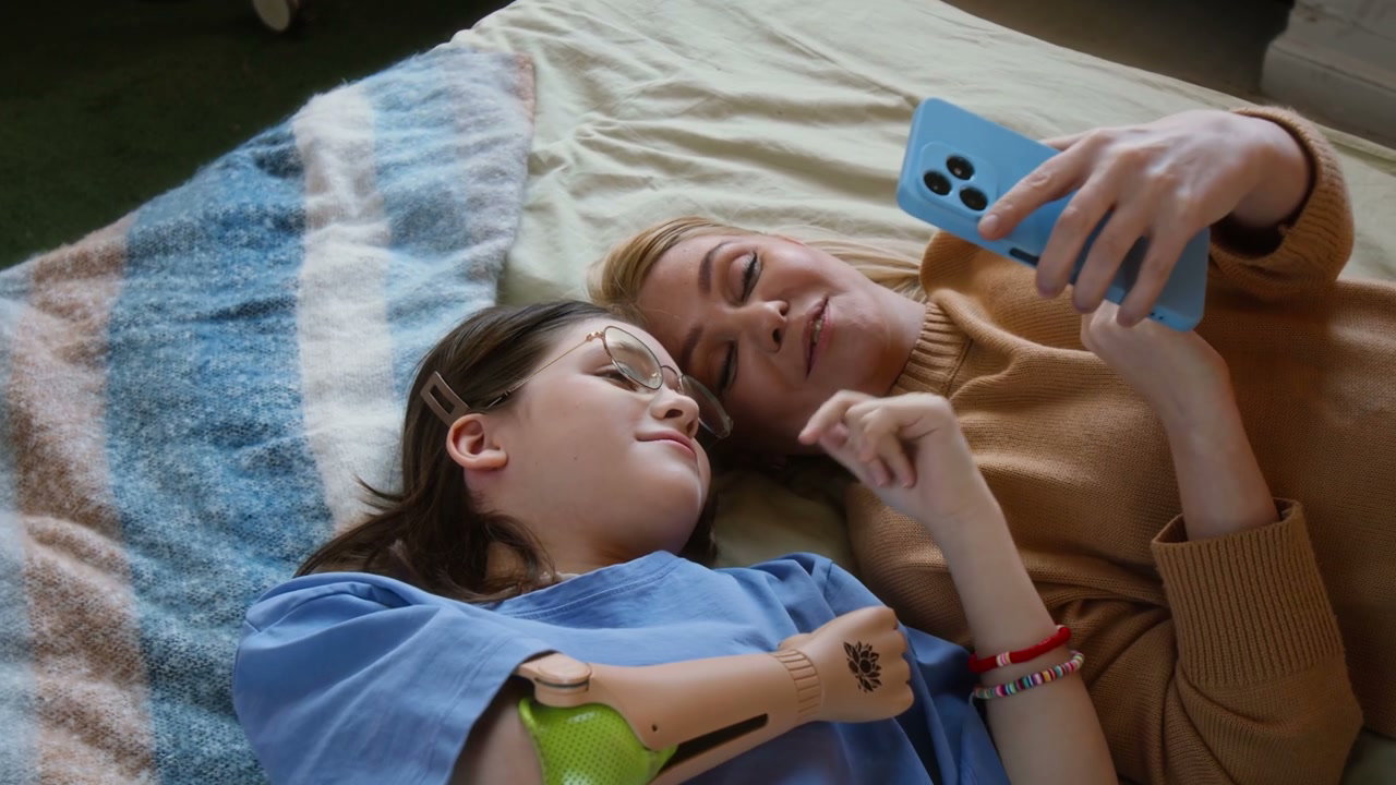 Mother And Daughter With Prosthetic Arm On Bed