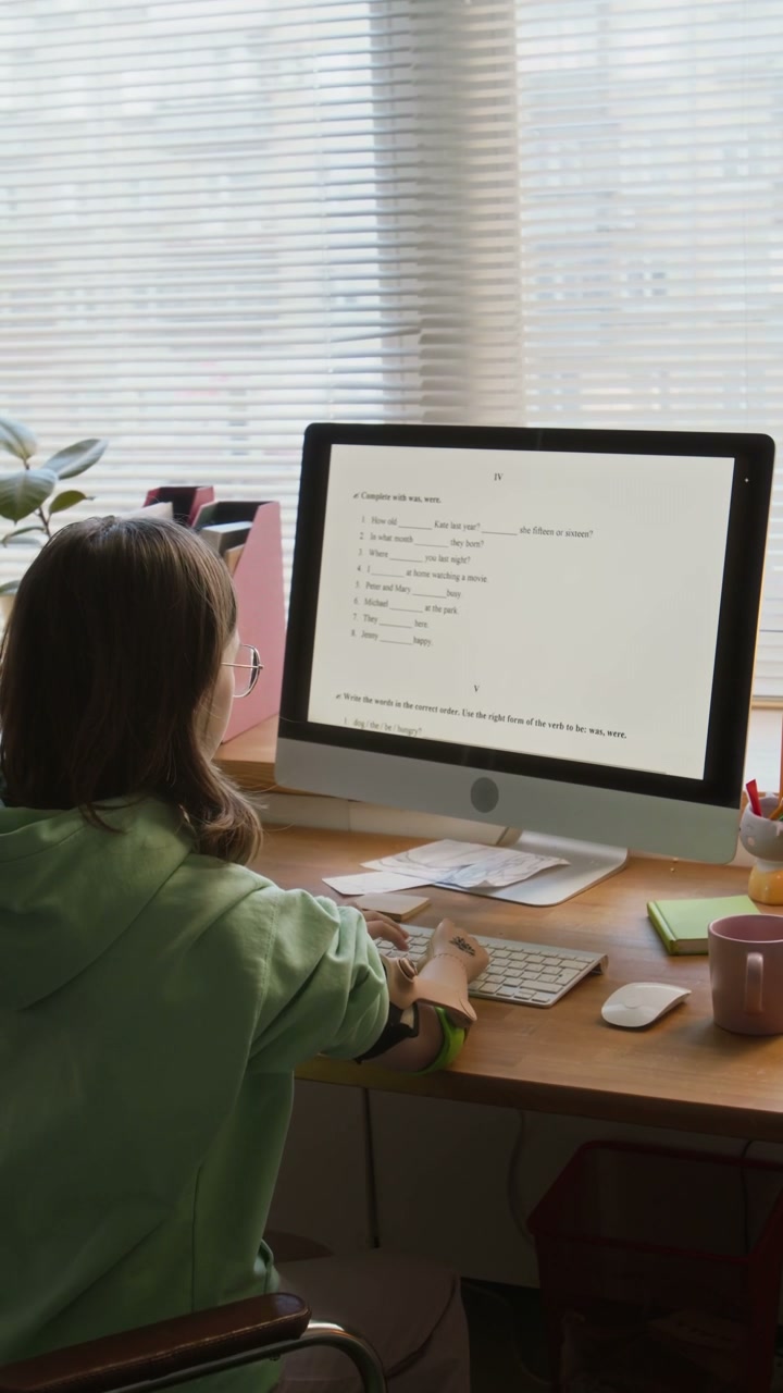 Young Woman with Prosthetic Arm Studying at Desk