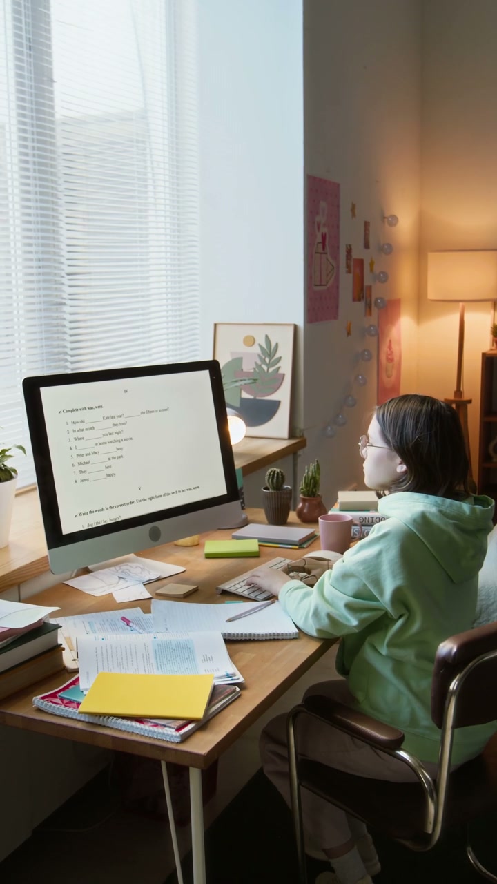 Teenage Girl with Prosthetic Arm Studying at Desk