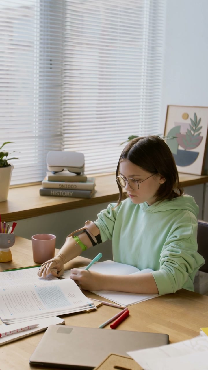 Teenage Girl with Prosthetic Arm Studying
