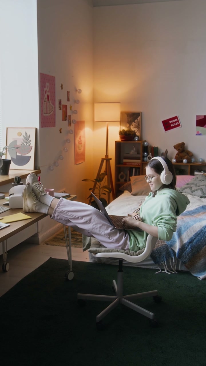 Young Woman Relaxing with Laptop in Bedroom