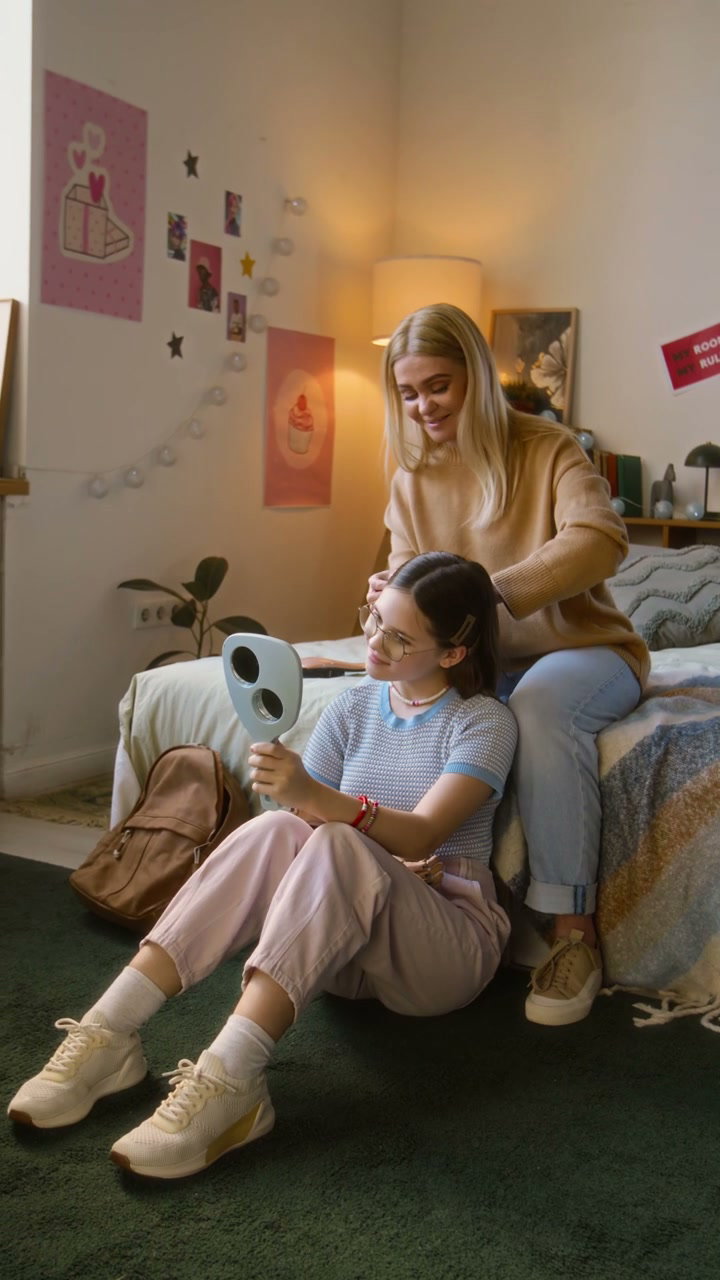 Mother Styling Daughter's Hair in Bedroom