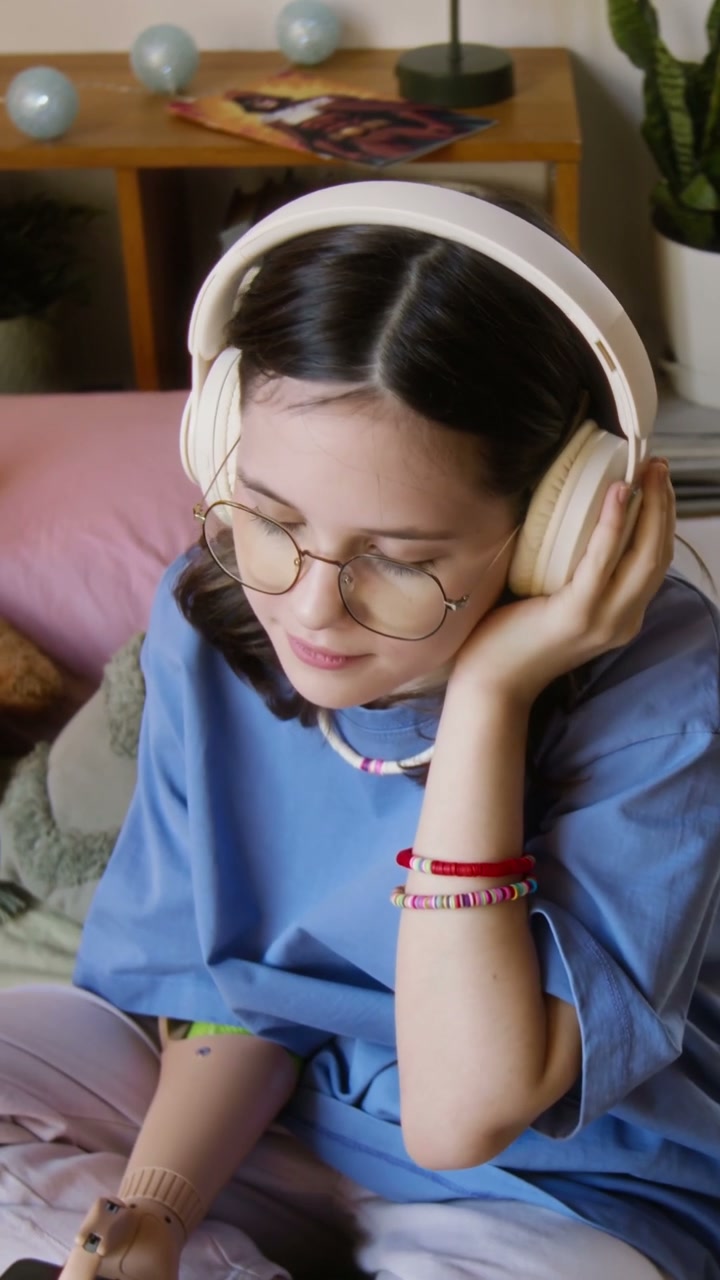 Young Person With Prosthetic Arm Listening to Music