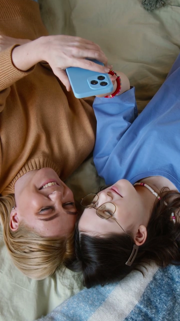 Mother and Daughter Relaxing with Smartphone