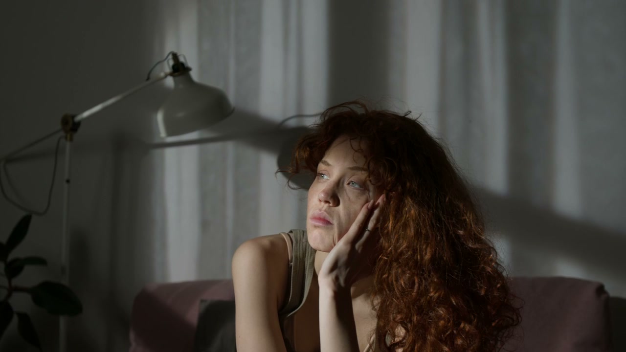 Depressed Woman Sitting Alone in Dim Room