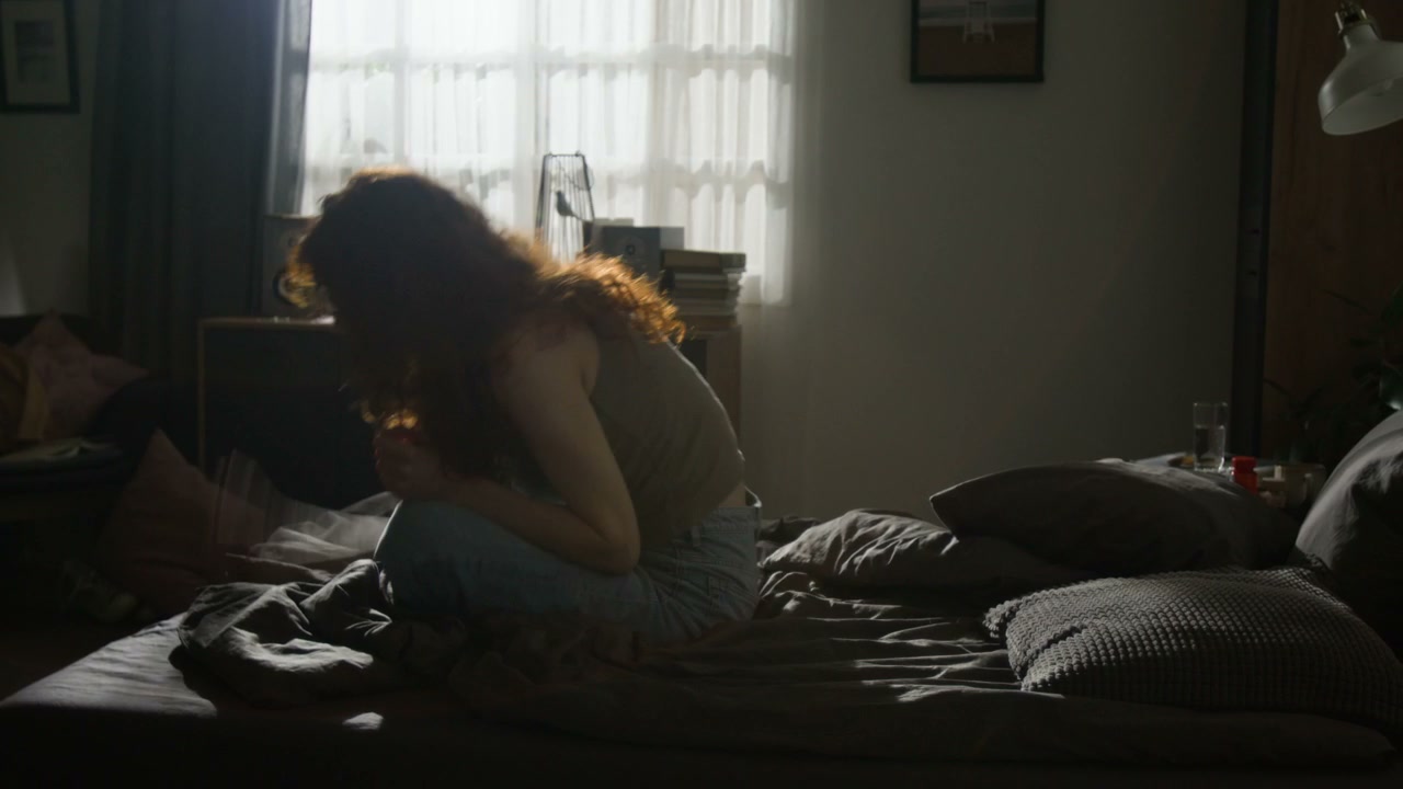 Distressed Woman Sitting on Bedroom Bed