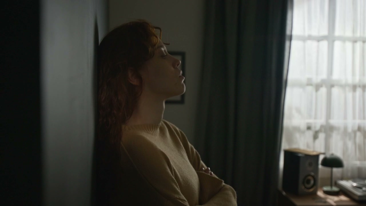 Pensive Woman Leaning Against Wall Indoors