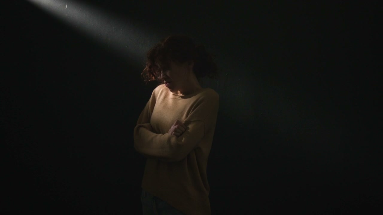Distressed Woman Screaming in Dark Studio