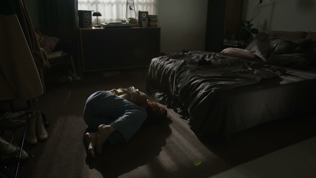 Distressed Woman Curled Up on Bedroom Floor