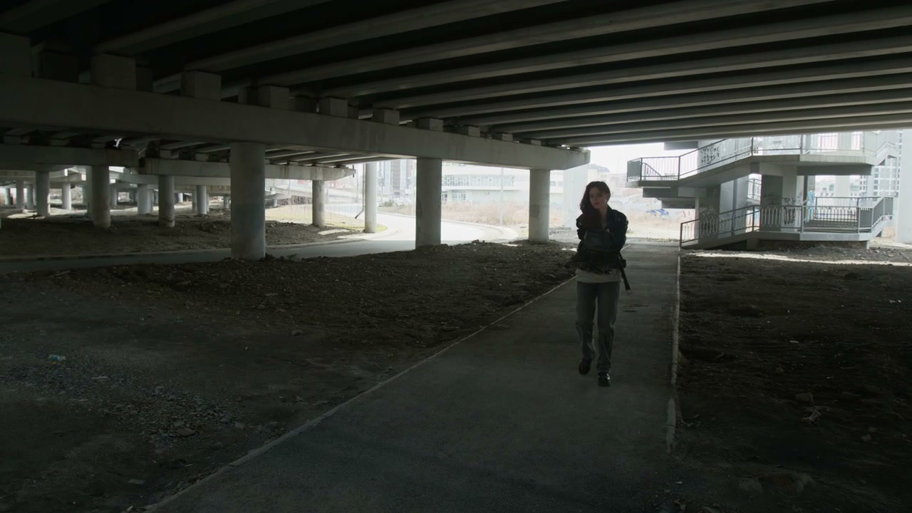 Sad Woman Walking Under Urban Overpass
