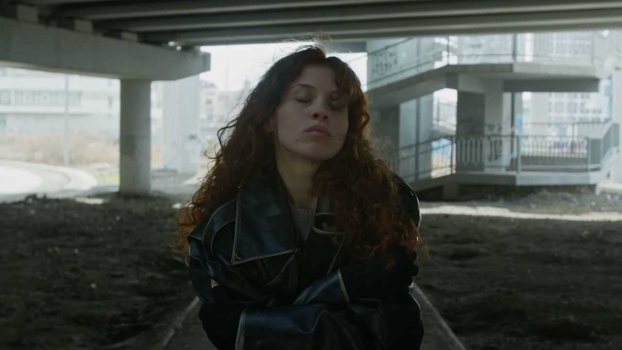Pensive Woman Walking Under Overpass
