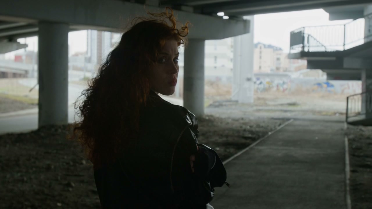 Pensive Woman Walking Under Overpass