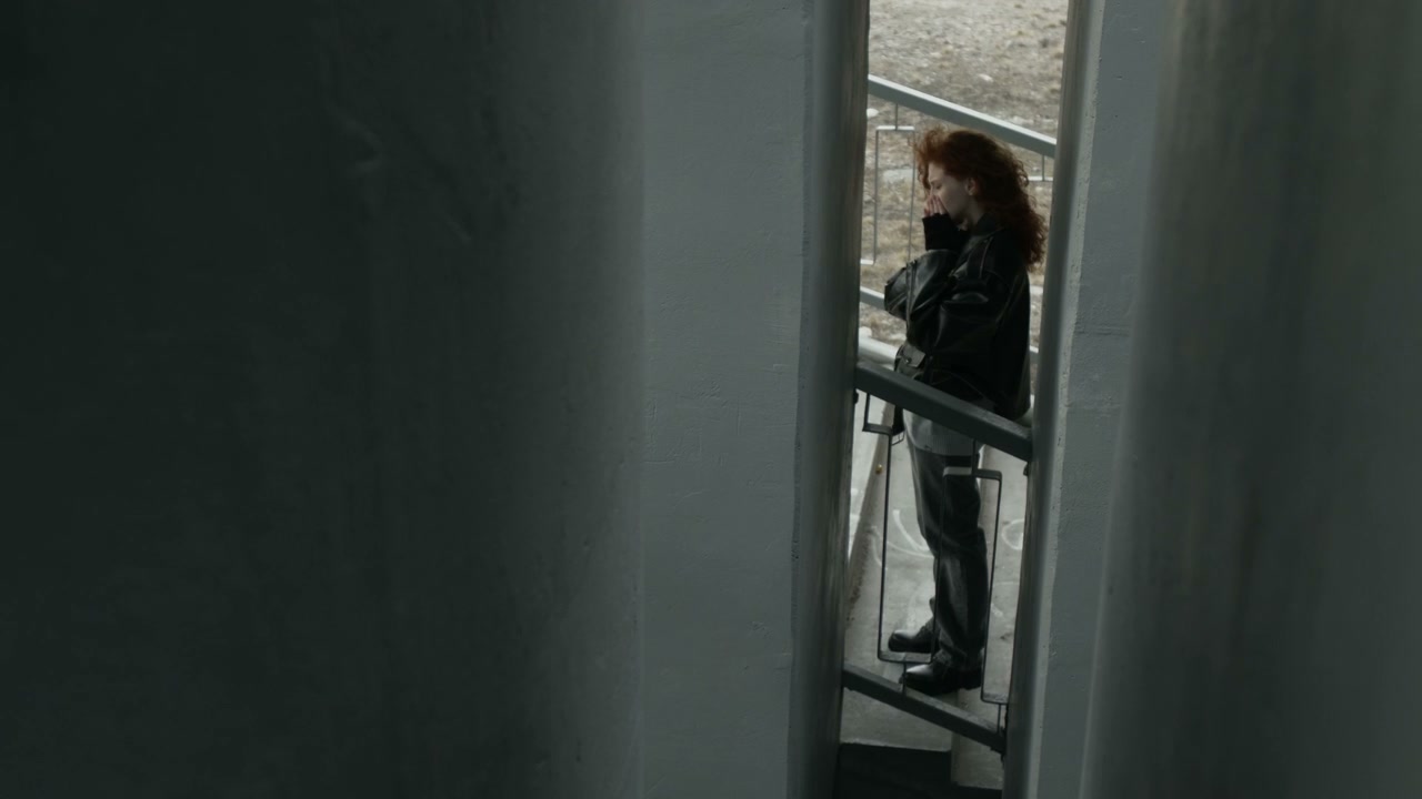 Pensive Young Woman on Concrete Stairwell