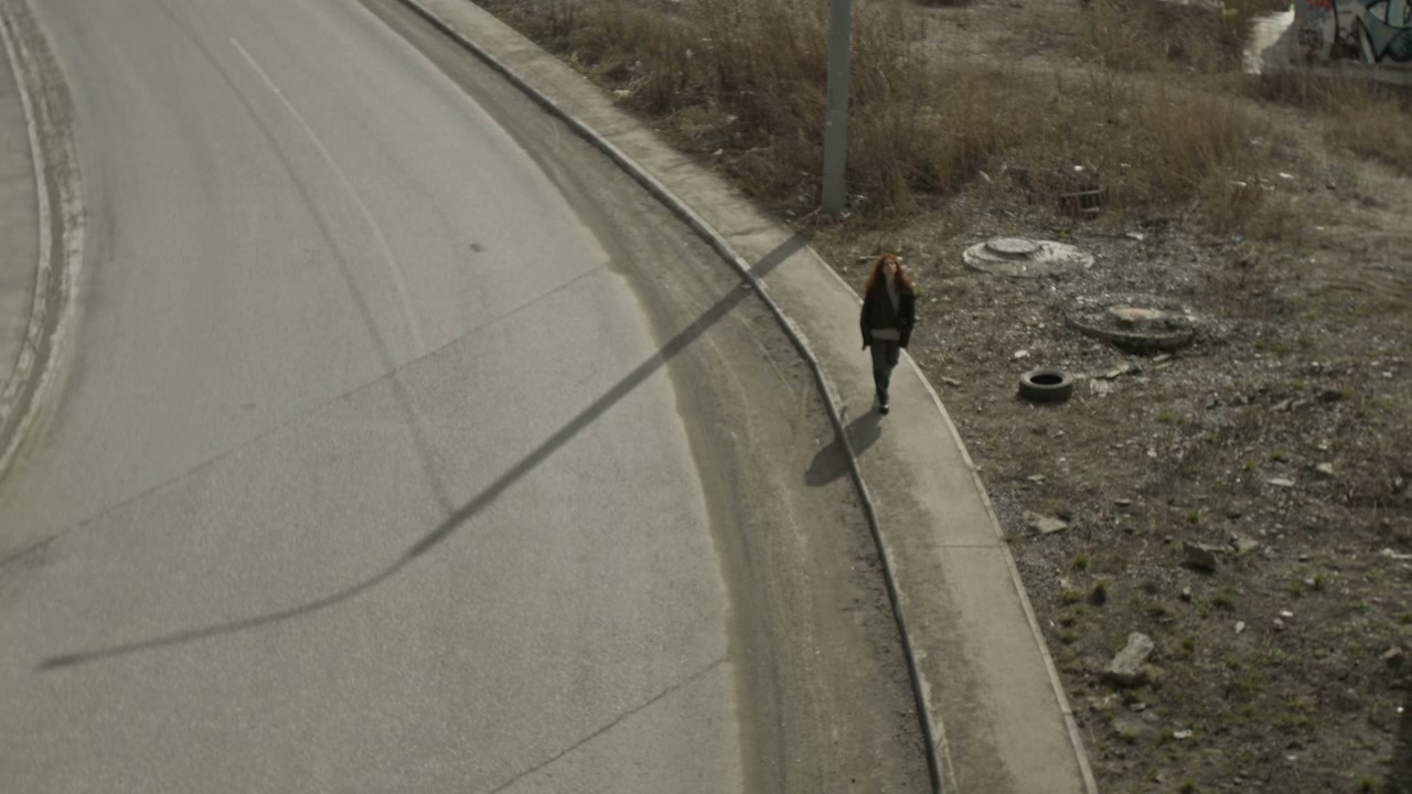 Pensive Woman Walking Alone on Urban Road