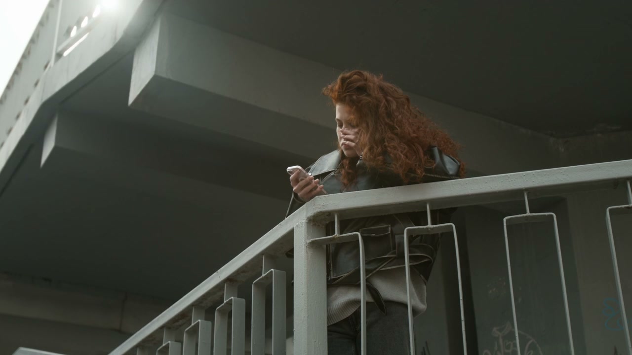 Pensive Woman Using Phone Under Bridge