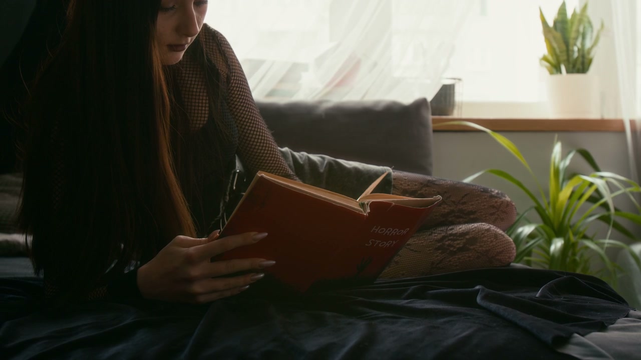 Young Woman Reading Horror Story Book